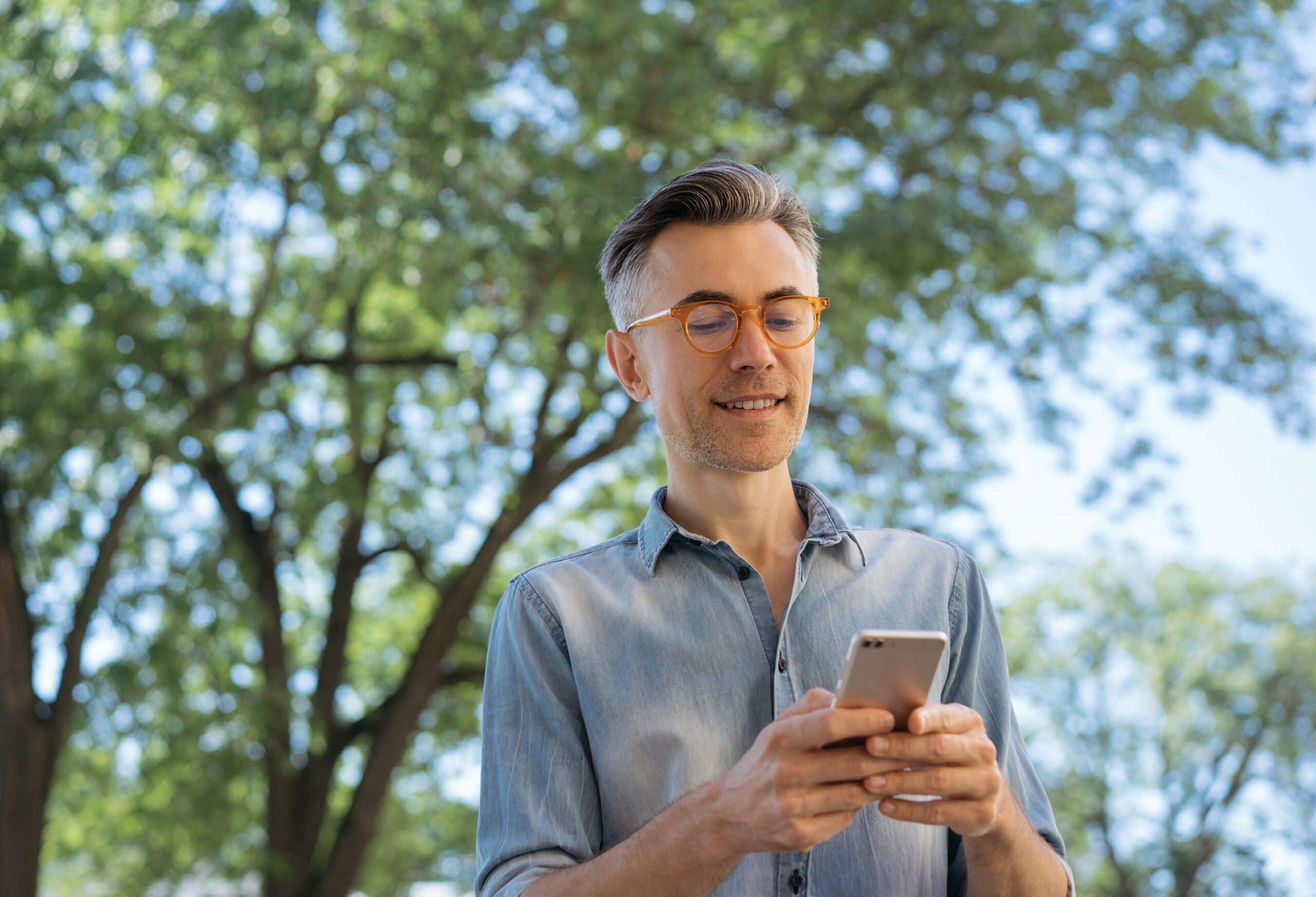 Un gestionnaire consulte une application sur son smartphone pour piloter les activités et les performances de son camping.